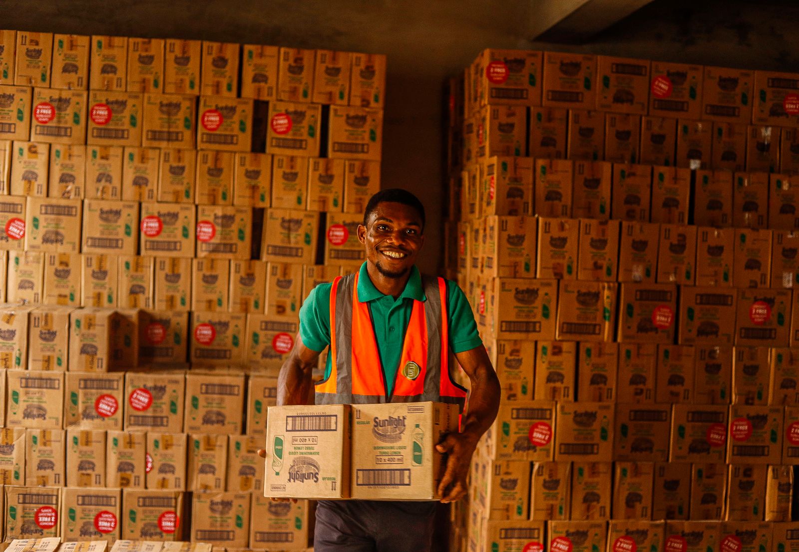 Smiling business owner carrying boxes in a warehouse