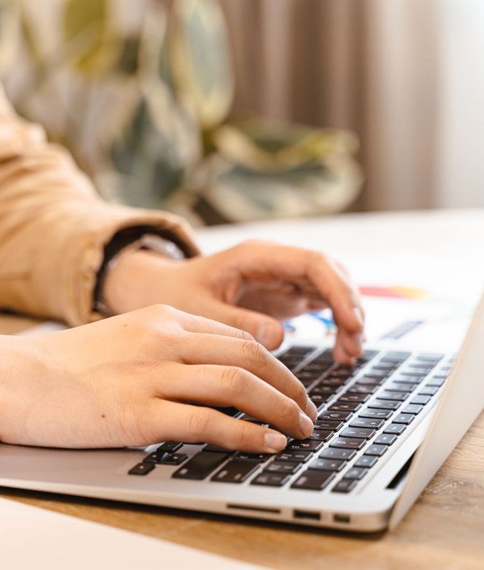Hands typing on a laptop